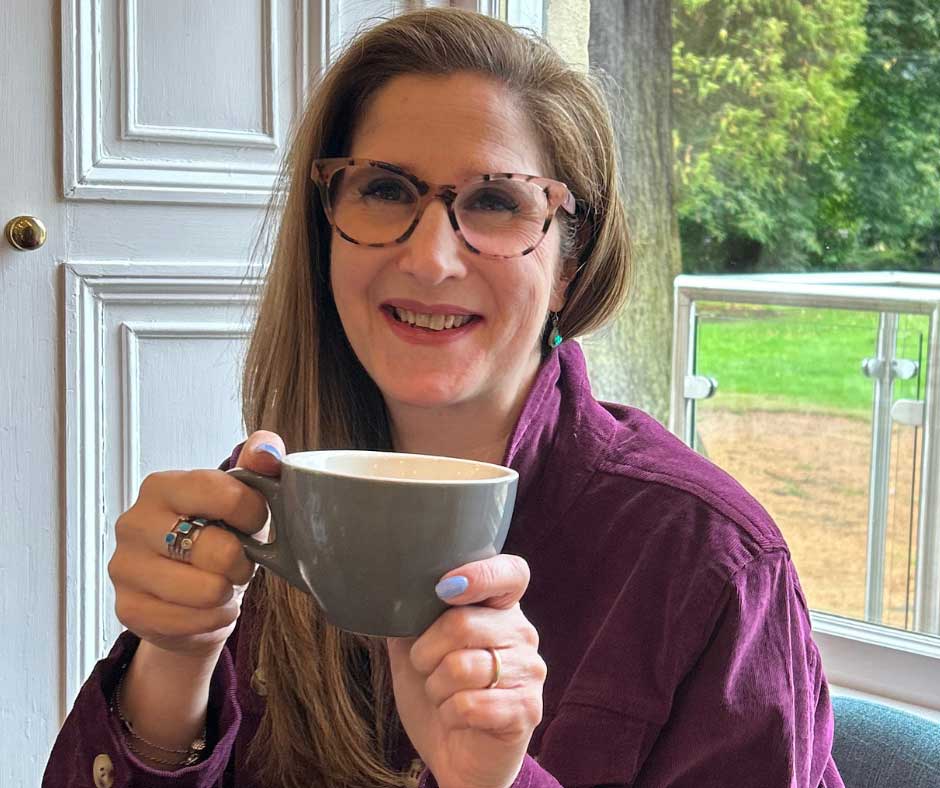 Jill Nicholson coaching, holding a cup of tea